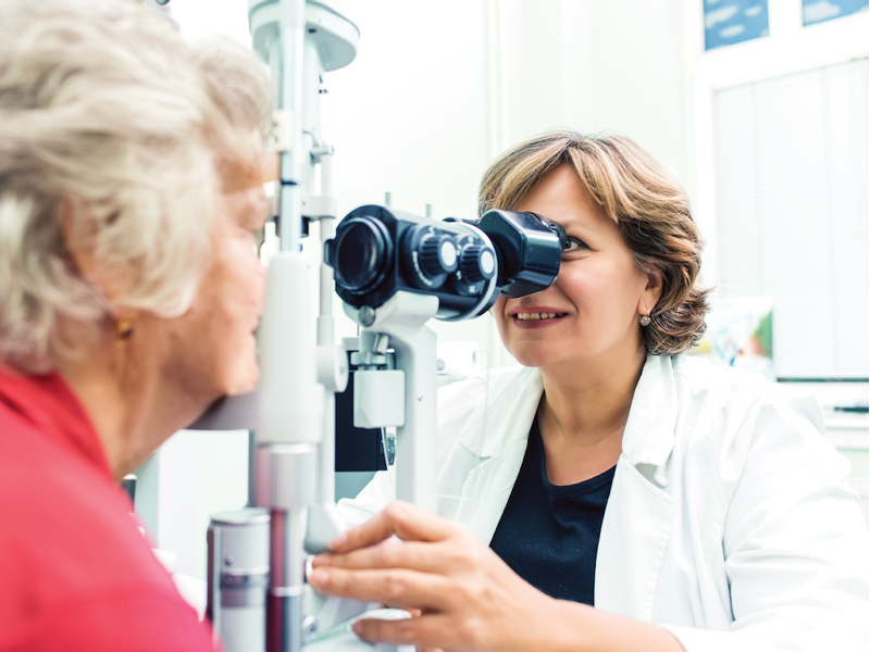 Image of older woman having an eye exam with an optometrist. Regular eye exams are important to reduce your risk of vision loss.