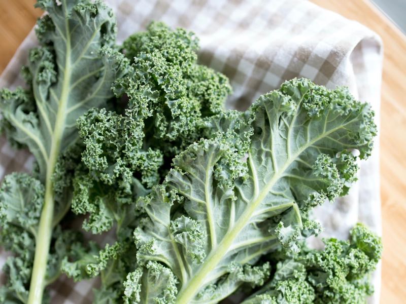 Image shows raw kale on a kitchen bench. 
